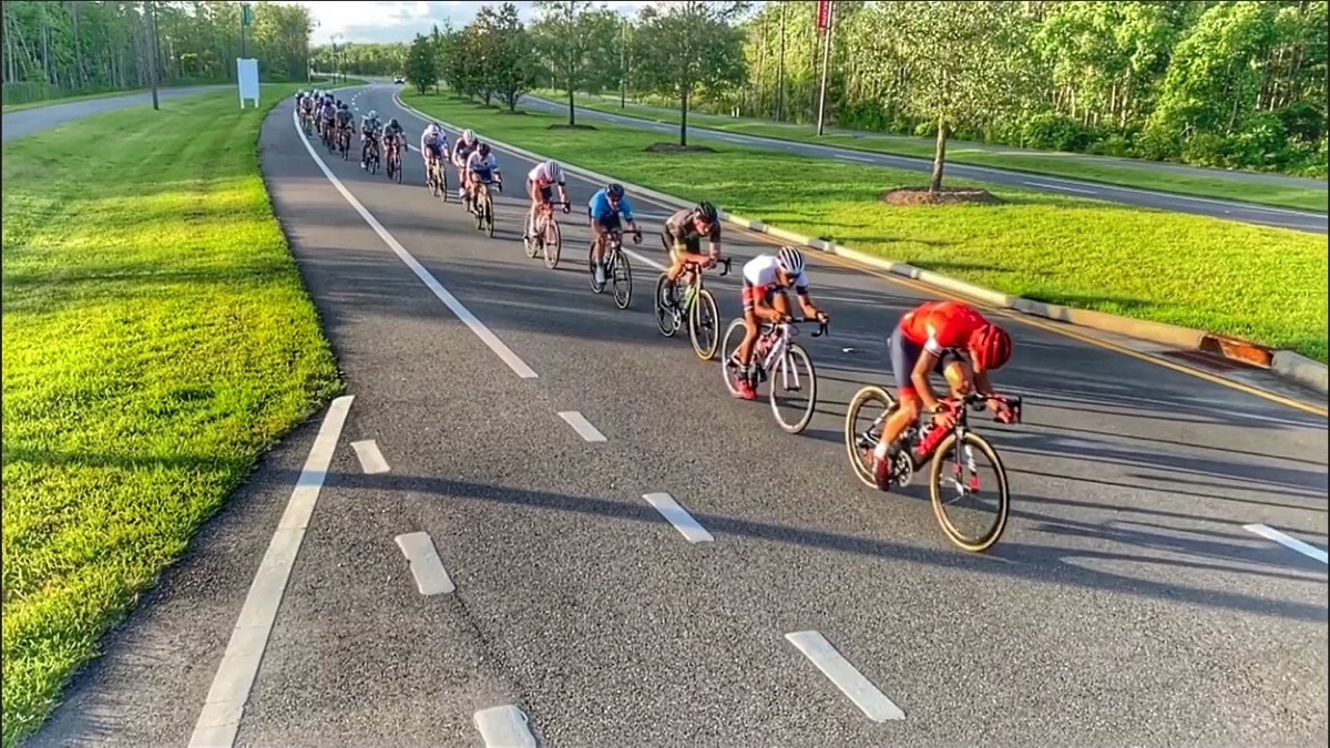 Aerial view of a Lodge Group Ride paceline stretched along a sunlit Ponte Vedra road.