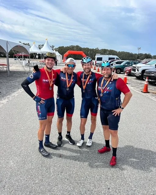 Four SP athletes wearing race medals together at a race finish area